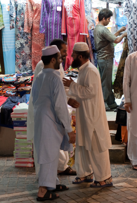 Omanske menn i omanske klær handler i en omansk suq
